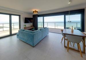 salon z niebieską kanapą i stołem w obiekcie Floryda Gardenia Seaside w Dziwnowie