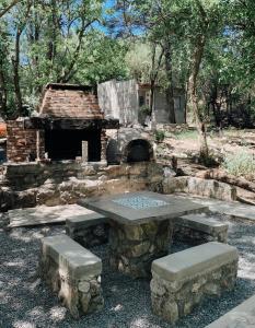 una mesa de picnic de piedra con un horno de piedra en un parque en Villa La Isolina en Villa Giardino
