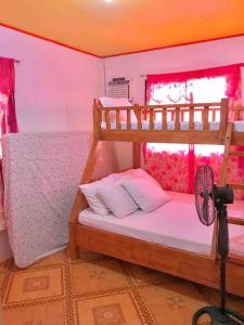 BolinaoにあるPatar beach Transient houseのベッドルーム1室(二段ベッド2台、ファン付)