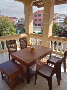 un tavolo in legno e 2 sedie su un portico di Makers Guesthouse a Siem Reap