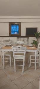 a dining room with a white table and chairs at Dependance Giardino in Umbertide
