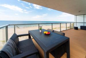 a table and chairs on a balcony with the beach at Floryda Gardenia Seaside in Dziwnów