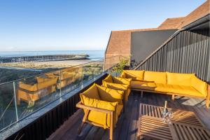 einen Balkon mit gelben Stühlen und Meerblick in der Unterkunft The Penthouse Nami, Branding, Ultra Luxurious Japanese Design Sea View in Cadzand