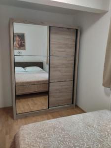 una camera da letto con un grande armadio in vetro con un letto di Apartment Seman a Vela Luka (Vallegrande)