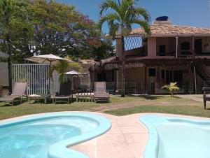 a swimming pool in front of a house at Pousada Praia do Flamengo Suítes in Salvador