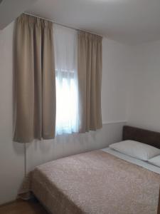 una camera con letto e finestra con tende di Apartment Seman a Vela Luka (Vallegrande)