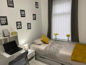 a bedroom with a bed and a desk with a laptop at Coastal Retreat-NEW DAY PROPERTIES-next to beach in South Shields