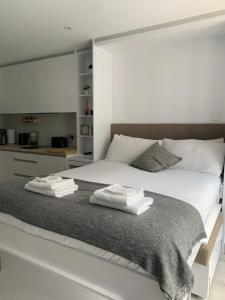 a bedroom with a large white bed with towels on it at CP High floor luxury studio in Gibraltar