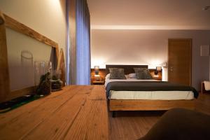 1 dormitorio con 1 cama y suelo de madera en Hotel Ristorante Pennar, en Asiago