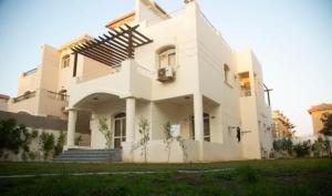 ein großes weißes Haus mit einer Veranda und einer Treppe in der Unterkunft فيلا الياسمين in ‘Ezbet `Abd el-Ḥamîd