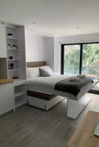 a white bedroom with a bed and a window at CP High floor luxury studio in Gibraltar