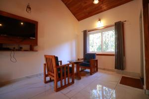 a dining room with a table and chairs and a television at Lazo Coffee Bean Resort in Madikeri