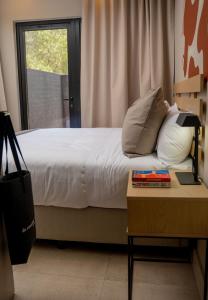 a bedroom with a bed with a table and a window at BlackBrick Sandton Two in Johannesburg +25 photos