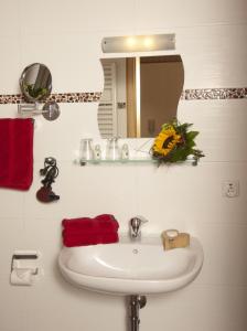ein weißes Waschbecken im Bad mit Spiegel in der Unterkunft Hotel Restaurant zum Schwanen in Bruchköbel