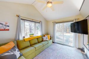 a living room with a couch and a flat screen tv at Riverbend Retreat in Jay