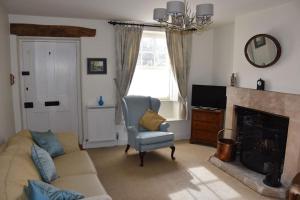 a living room with a couch and a fireplace at Riverside Cottage in Lower Slaughter
