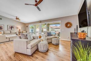 a living room with white furniture and a ceiling fan at Warm Welcomes on Wahalla Lane in Glendale