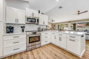 a kitchen with white cabinets and white appliances at Warm Welcomes on Wahalla Lane in Glendale