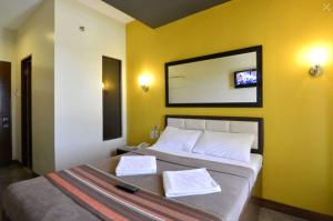 Express Inn Mactan في ماكتان: غرفة نوم بسرير كبير عليها منشفتين