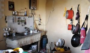 eine Küche mit einer Spüle und einer Theke mit Töpfen und Pfannen in der Unterkunft Hidden place in Siwa