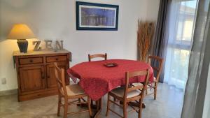 stół jadalny i krzesła z czerwoną tkaniną w obiekcie COSY LODGE GITE APPARTEMENT MEUBLE CiTY BREAK w Tuluzie