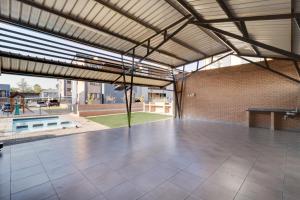 a large room with a tile floor and a brick wall at The Lillies Luxury Apartment in Midrand