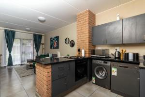 a kitchen with a washer and dryer in a room at The Lillies Luxury Apartment in Midrand