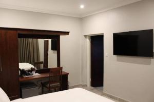 a bedroom with a desk and a television on a wall at A pristine BB located in Belvedere Harare - 2006 in Harare