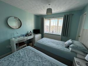 a bedroom with two beds and a desk and a mirror at Leeward House B&B in Gosport +18 photos
