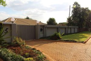 a house with a fence and a brick driveway at A pristine BB located in Belvedere Harare - 2006 in Harare