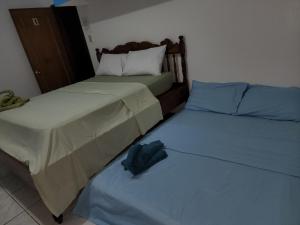 布桑加的住宿－Bella Louise Bar Resto，卧室内两张并排的床