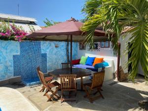 een tafel en stoelen met een parasol en een bank bij Luciano & Grace Apartments in Watamu