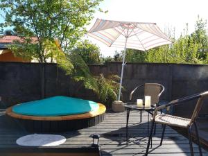 a patio with a hot tub and a table and an umbrella at Cabañas Alto Centro, Departamento N 2 in La Unión