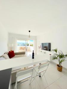 un soggiorno bianco con scrivania e sedie bianche di Marco´s Senator Suite a Costa Teguise
