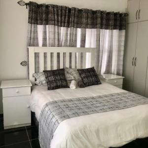 a bedroom with a white bed with a teddy bear on it at 1 bed apartment in Mount Pleasant Heights - 2014 in Kingsmead