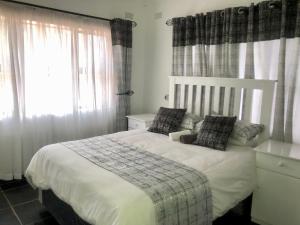a bedroom with a bed and a window with curtains at 1 bed apartment in Mount Pleasant Heights - 2014 in Kingsmead