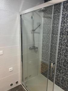 um chuveiro com uma porta de vidro na casa de banho em Casa dos Doces em Póvoa de Lanhoso