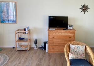 ein Wohnzimmer mit einem TV und einer Holzkommode in der Unterkunft Ferienwohnung Plöner See in Ascheberg