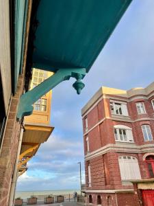 Cette chambre offre une vue sur un bâtiment en briques doté d'un plafond bleu. dans l'établissement La Batelière, appartement mer avec patio privé, à Mers-les-Bains 19 autres photos