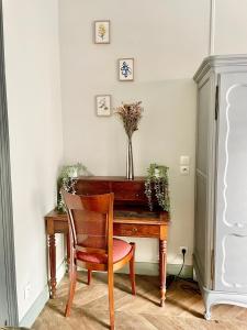 un bureau en bois avec une chaise et un vase de fleurs dans l'établissement La Batelière, appartement mer avec patio privé, à Mers-les-Bains