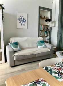 - un salon avec un canapé et une table dans l'établissement La Batelière, appartement mer avec patio privé, à Mers-les-Bains