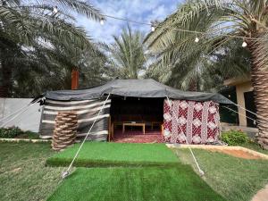 a tent with a picnic table in a yard at Ezdan Chalet in Unayzah