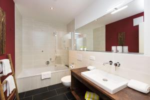 a bathroom with a sink and a tub and a toilet at Chalet am Breitenberg Appartement CB 04 in Pfronten