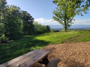 a wooden bench sitting in the middle of a field at L'essentiel in Montilliez