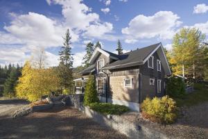 ein Haus mit einer steinernen Wand davor in der Unterkunft Vuokatin Aateli Villa Marsalkka in Vuokatti