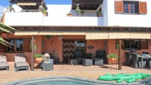 a pool in front of a house with a lizard in the yard at Villa Panoramica in Yaiza