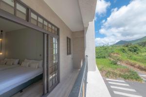1 dormitorio con 1 cama y balcón con vistas. en HiHi Skylight, en Hengchun