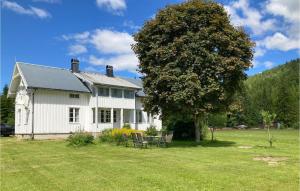 una casa blanca con un árbol en el patio en Nice Home In Passebekk With 3 Bedrooms And Wifi en Svarstad