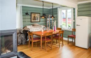 a dining room with a wooden table and chairs at Nice Home In Passebekk With 3 Bedrooms And Wifi in Svarstad