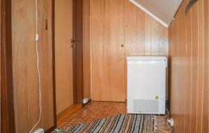 Habitación con paredes de madera y nevera pequeña. en Nice Home In Passebekk With 3 Bedrooms And Wifi en Svarstad